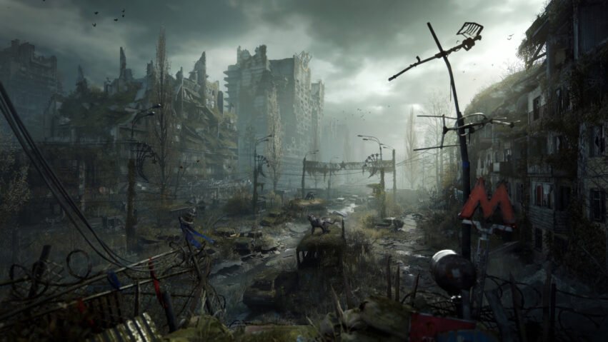 Desolate ruined city street with crumbling buildings, overgrown vegetation, and abandoned vehicles, viewed from a barbed-wire fence.