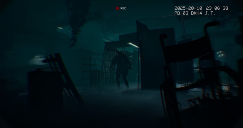 Silhouetted zombie-like figure in a dim, foggy industrial interior with scattered debris and a chain-link fence, plus a video timestamp and red REC indicator at the top.