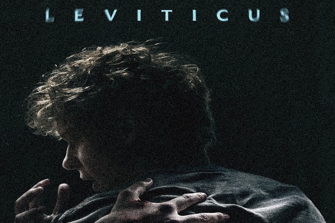 Man seen from behind in a dark, grainy image, hands gripping his coat as blue LEVITICUS text appears at the top.