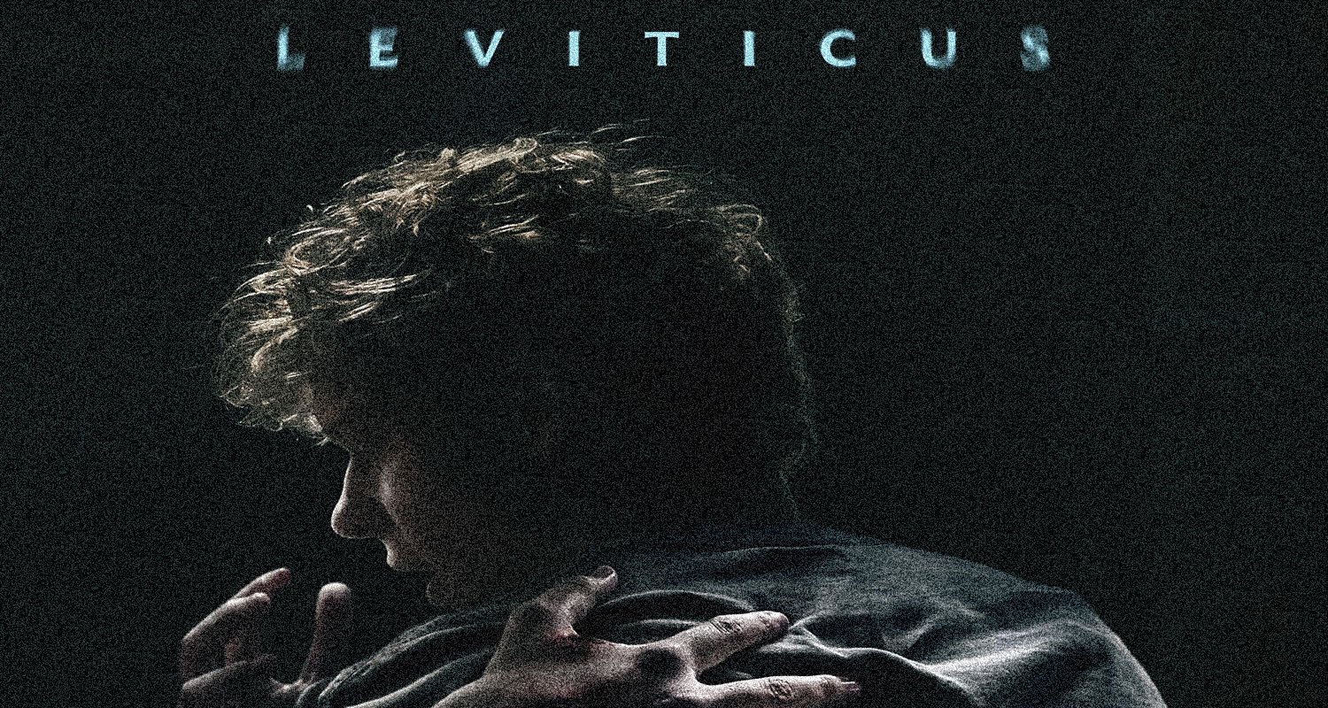 Man seen from behind in a dark, grainy image, hands gripping his coat as blue LEVITICUS text appears at the top.