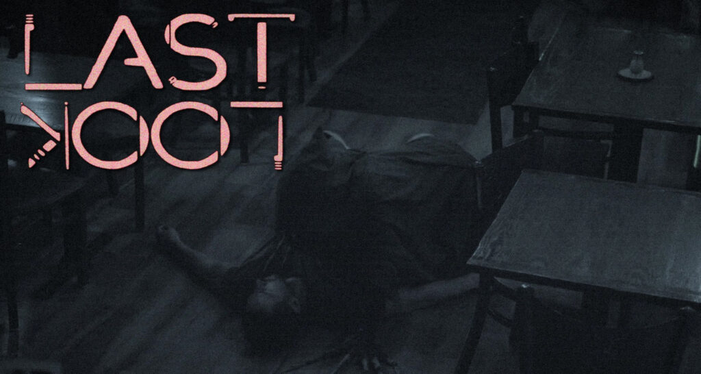 Dim, moody room with large pink neon text saying 'LAST EXIT' and a person crawling on the dark floor beside tables and chairs.