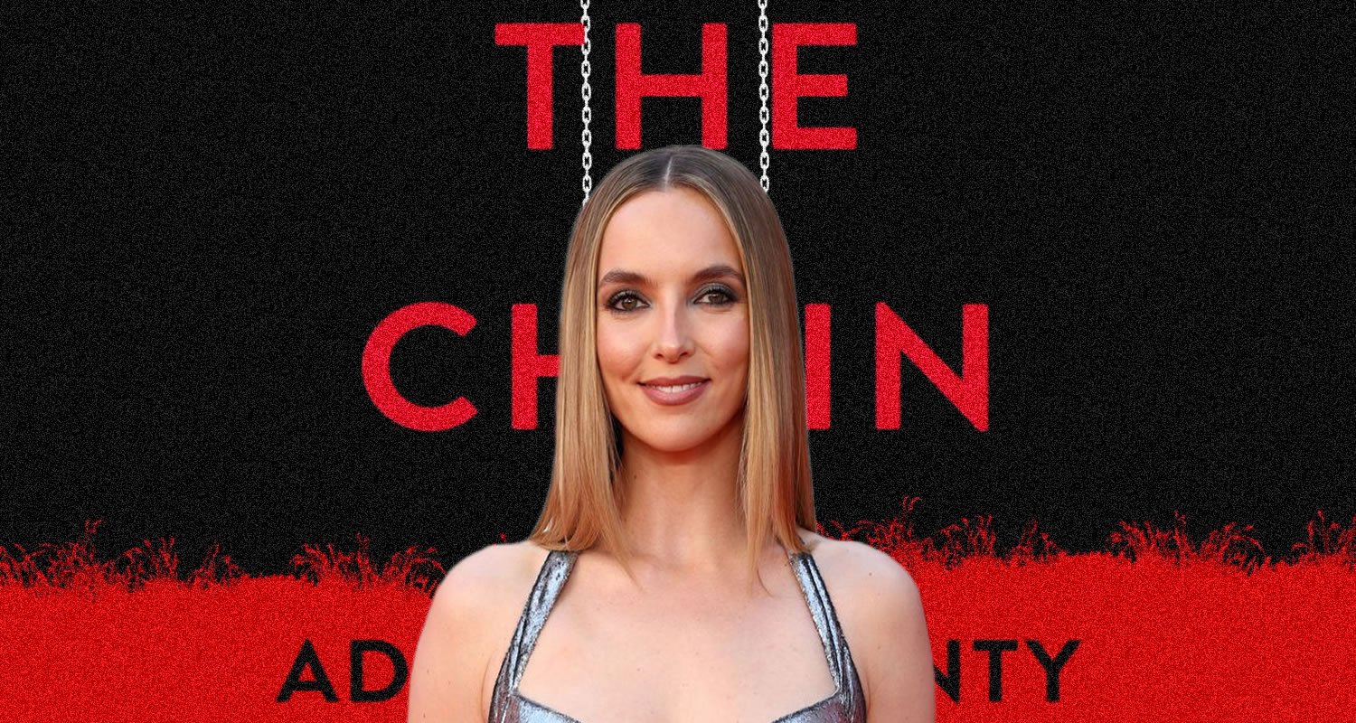 Portrait of a woman on the red carpet, standing in front of a black-and-red poster reading 'THE CHAIN' with hanging chains imagery.