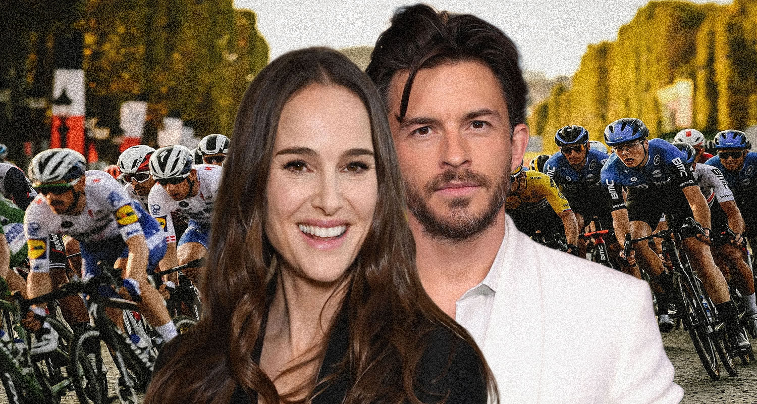 Smiling couple posing in front of a cycling race scene on the road with cyclists in motion behind them, crowding the background.