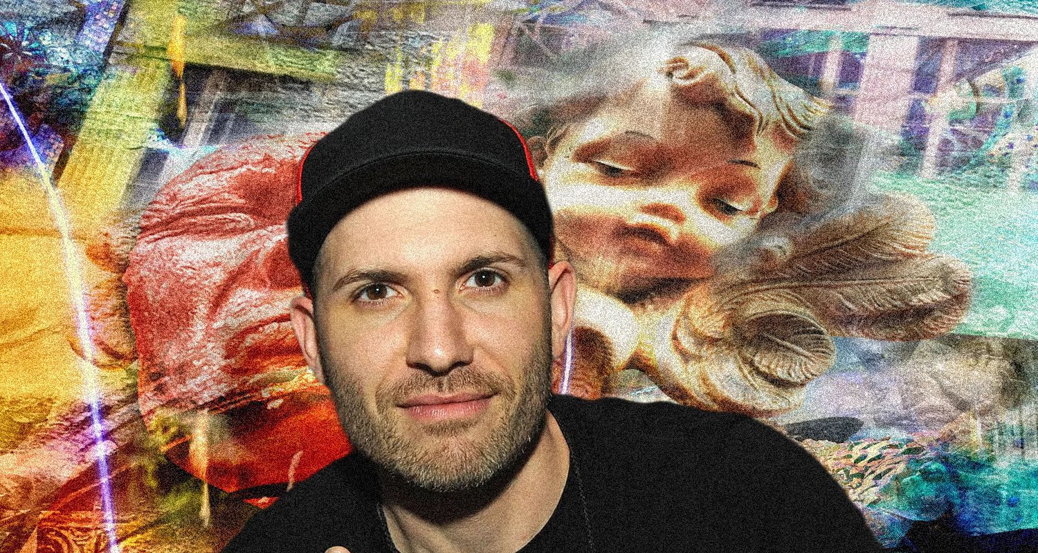 Man wearing a black cap and dark shirt posing in front of a vibrant graffiti mural featuring a large sleeping cherub image.