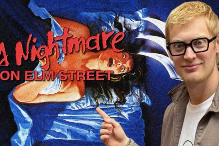 Young man with blond hair and glasses posing beside a 'A Nightmare on Elm Street' poster, which shows a screaming woman in blue.