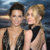 Two women in evening gowns pose together in front of a dark, stormy sea with a lightning bolt in the distance.