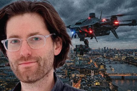 Man with clear glasses in the foreground; a drone hovering above a city skyline at dusk.