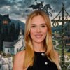 Portrait of a smiling blonde woman in a black sleeveless top, overlaid on a collage of a village festival and a dark fantasy scene with a horse and symbols.