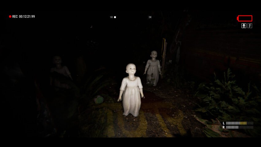 Dark outdoor scene with three eerie porcelain dolls in white dresses; haunted atmosphere in a dim yard, with a video camera HUD overlay.