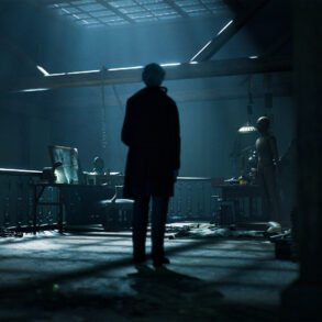 Silhouetted figure in a dim, blue-lit workshop facing a workbench and a life-size mannequin.