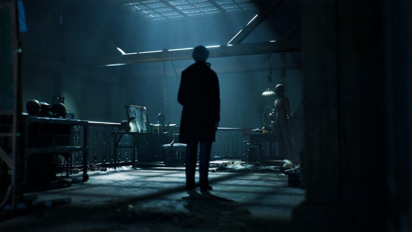 Silhouetted figure in a dim, blue-lit workshop facing a workbench and a life-size mannequin.