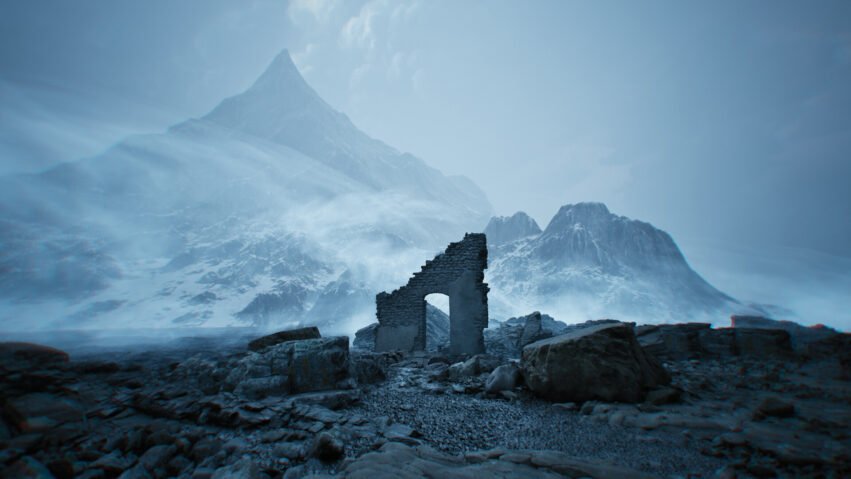 Ruined stone arch sits among rocks with a snow-covered mountain range in a blue-tinted, misty landscape.