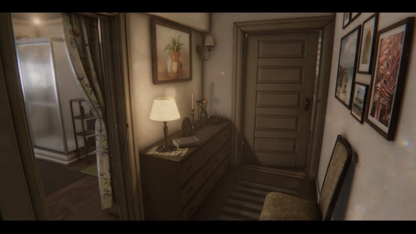 Cozy hallway with a dresser, lamp, and framed paintings along the walls. A striped rug runs beside it, and a closed paneled door is at the end.