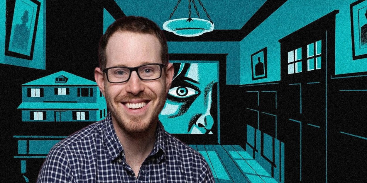 Smiling man with glasses in front of a teal-and-black mural featuring a large eye and architectural panels.